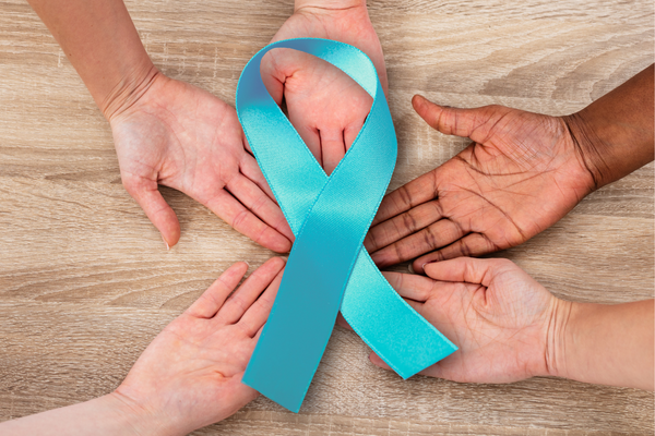 Hands gathered around a blue cervical cancer ribbon